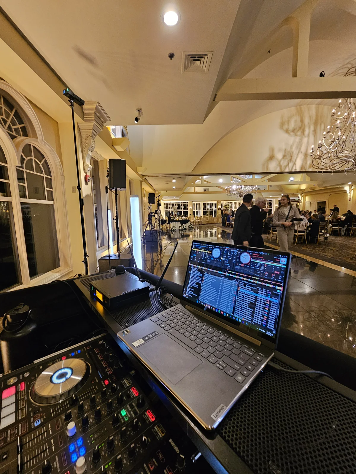 DJ controller and laptop set up at the front of a reception room
