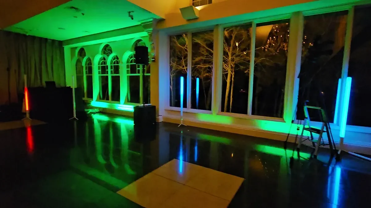 Green and red uplighting glowing across an empty event room before guests arrive