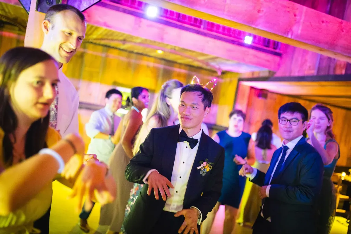 Wedding guests dancing under colorful lighting at a Michael Sage reception