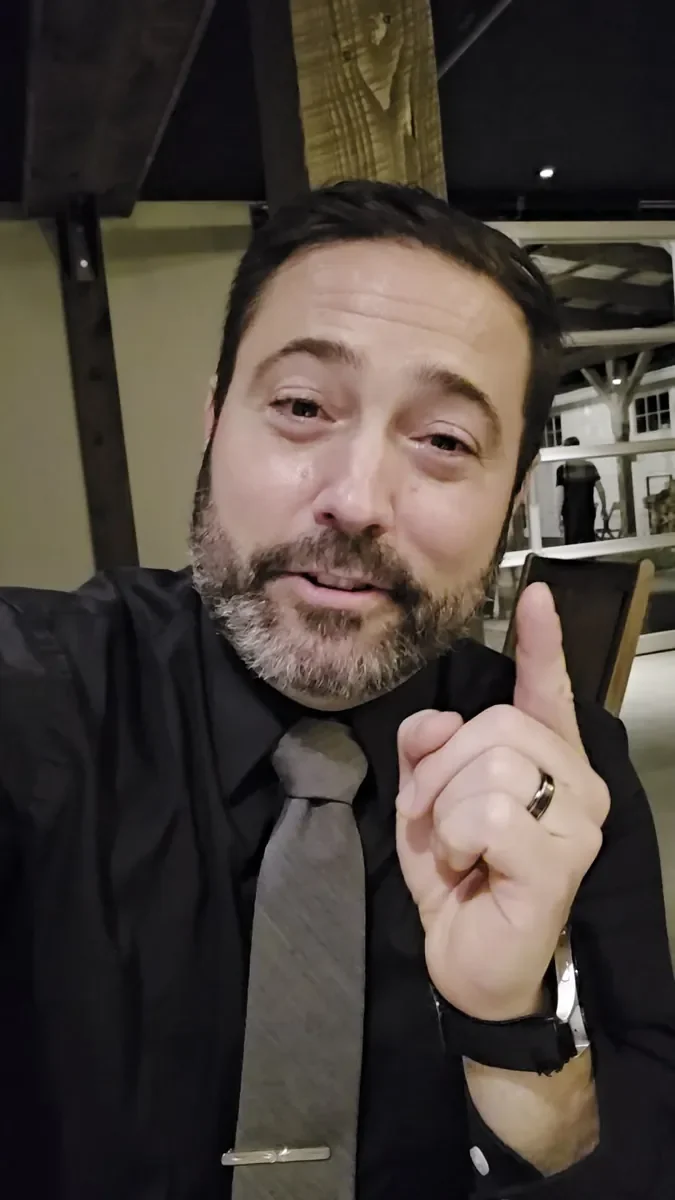 Michael Sage, Westport wedding DJ and MC, smiling and pointing up in a selfie at an event