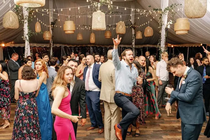 Guests dancing under a tent at a wedding with Michael Sage